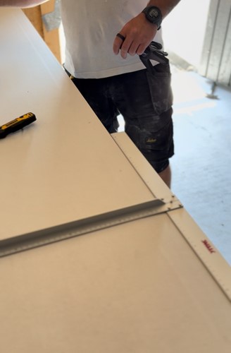 Tømrer med SVALK Gipsvinkel PROF og NORSE-handsker under præcisionsarbejde.